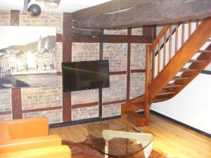 un salon avec une télévision et un escalier dans l'établissement Amosa Liège City Centre Apart Gerardrie 17, à Liège