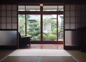 sala de estar con puerta abierta a un jardín en Hostel Amaou, en Oki