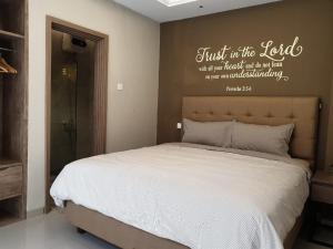 a bedroom with a bed with the words trust in the lord at Danka@Taman Golf Residence in Batam Center
