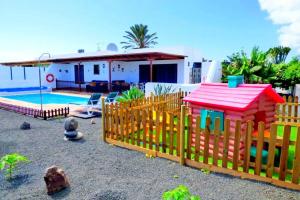 a wooden fence in front of a house with a pool at Villa Raima in Playa Blanca