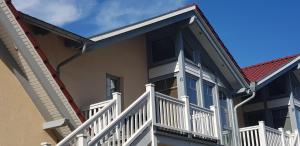 a house with a white railing and a balcony at FeWo an der Ostsee Nr. 3 in Rerik