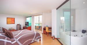 1 dormitorio con 1 cama y baño con bañera en Hotel Casa Victoria, en Medellín