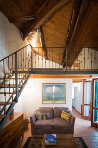a living room with a couch and a staircase at Vuotopieno Casa Blue Maremma in Orbetello