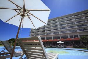 a chair and an umbrella next to a hotel at Ishigaki Seaside Hotel in Ishigaki Island