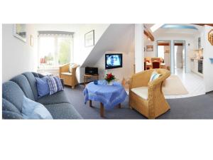 ein Wohnzimmer mit einem blauen Sofa und Stühlen in der Unterkunft Ferienhof Andreas Hansen in Rettin