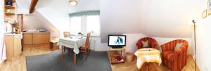 ein Wohnzimmer mit einem Tisch und einer Küche in der Unterkunft Ferienhof Andreas Hansen in Rettin