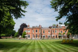 a large brick building with chairs on a grass field at Royal Berkshire in Ascot