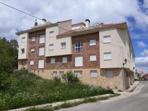 a brick building on the side of a street at La Pérgola Apartamento Sierra de Albarracín Planta baja y Garaje in Bronchales
