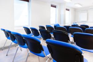 une salle de classe vide avec des chaises bleues dans l'établissement Hotell Mörby - Danderyd Hospital, à Danderyd