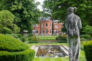 een standbeeld voor een tuin met een gebouw bij Royal Berkshire in Ascot