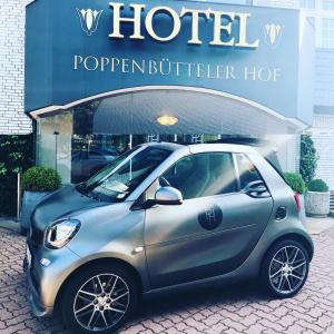a small car parked in front of a hotel at Boutique Hotel Poppenbütteler Hof in Hamburg