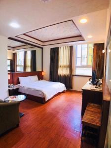 礁溪鄉的住宿－玉泉旅館，配有一张床和一张书桌的酒店客房