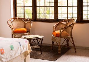 two chairs and a table and a bed in a room at Dolce Casa in Colombo