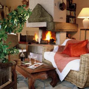 a living room with a fireplace and a couch and a table at Hôtel Restaurant Taillard in Goumois