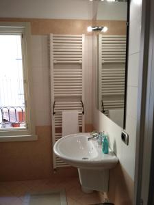 un bagno con lavandino, specchio e finestra di I Gechi a Verona