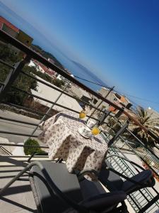 a table sitting on a chair under an umbrella at Apartments Nataly with FREE PARKING in Makarska