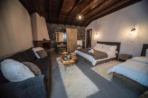 een slaapkamer met een bed en een bank en een bed en een tv bij Guesthouse Nefeli in Palaios Agios Athanasios
