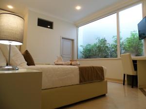 a bedroom with a bed and a large window at Bowen, Luxury Suites in Lagos