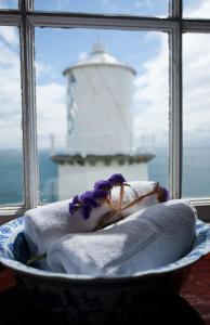 a bowl of towels with a lighthouse in the background at Blackhead Lighkeeper's Houses, Antrim in Whitehead