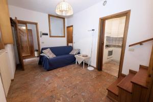 ein Wohnzimmer mit einem blauen Sofa und einem Tisch in der Unterkunft Appartamenti Raineri in Domaso