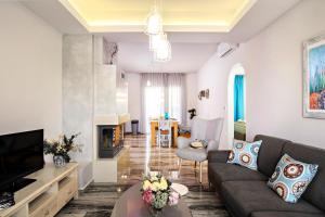 Una sala de estar con un sofá y un televisor. en Beachside Apartment in Plakias centre!, en Plakias