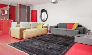 a living room with two couches and a rug at By Best Apartments in Tirana