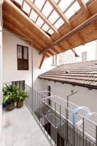an outdoor patio with a wooden roof and a metal railing at Appartamenti Raineri in Domaso