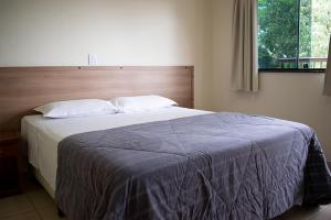a bedroom with a large bed with a blue blanket at Hotel Villagio D'Italia in Vinhedo