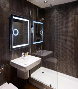 a bathroom with a sink and a shower and a mirror at The Motel, Ribby Hall Village in Wrea Green