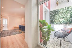 una camera con una pianta in vaso e un soggiorno di Avenida da Liberdade Apartment a Lisbona