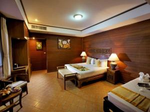 a hotel room with a bed and a chair and a table at Smile House - Fisherman Village in Bophut