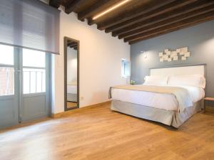 a bedroom with a large bed and a wooden floor at Aldaba Apartamentos in Toledo
