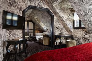 a bedroom with a bed and a large mirror at Le Pavillon de la Reine & Spa - Small Luxury Hotels of the World in Paris
