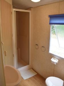 La salle de bains est pourvue d'une douche, de toilettes et d'un lavabo. dans l'établissement Village de Chalets de Rocamadour, à Rocamadour