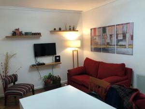 a living room with a red couch and a tv at Small & Comfortable Apartment in Palermo in Buenos Aires