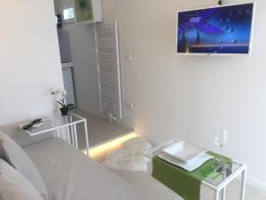 a living room with a couch and a tv on the wall at Privatzeit The green Mile in Leverkusen
