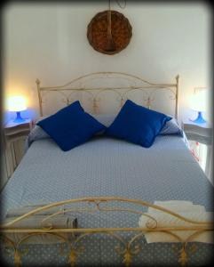 - un lit avec des oreillers bleus au-dessus dans l'établissement La Casa Sotto L'arco, à Termoli