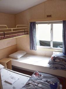Cette chambre comprend 2 lits superposés et une fenêtre. dans l'établissement Village de Chalets de Rocamadour, à Rocamadour