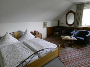 a bedroom with a bed and a living room at Gasthaus Zur Burgschänke in Aremberg