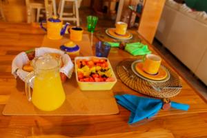 a table topped with a tray of fruit and juice at Serendipity Hospedaje Boutique in Guatapé