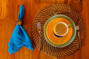 una mesa con una taza de café y un tenedor y un cuchillo en Serendipity Hospedaje Boutique, en Guatapé