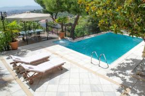 a swimming pool with two chairs and a table at Apartments Nina in Athens