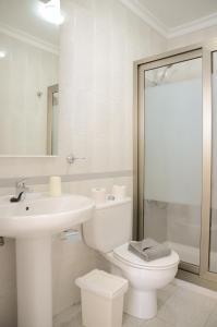 a white bathroom with a toilet and a sink at Apartamentos El Marinero - Avenida in Caleta de Sebo
