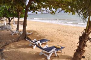 two lounge chairs and a table on a beach at Sunshine Beach Condotel in Na Jomtien