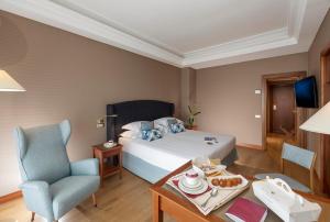 a hotel room with a bed and a table and a chair at Hotel Royal Continental in Naples