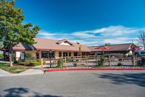ein Gebäude mit einem Zaun vor einer Straße in der Unterkunft Sun Outdoors Central Coast Wine Country in Paso Robles