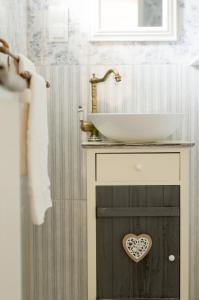 a bathroom with a sink and a counter with a heart sign on it at Villa Harmónia in Gyula