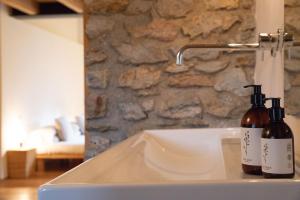 two bottles of wine sitting on top of a sink at Cal Calsot Casa Rural "Adults Only" in Montellá