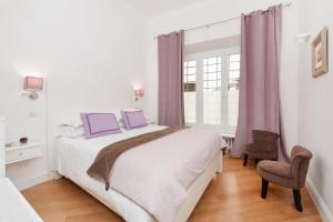 ローマにあるLovatelli Home al Campidoglioのベッドルーム1室(ベッド1台、椅子、窓付)