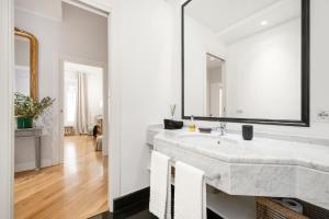 een badkamer met een grote marmeren wastafel en een spiegel bij Lovatelli Home al Campidoglio in Rome